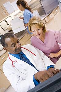 A Doctor And Nurse Discussing Something At The Reception Area Of A Hospital