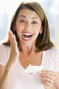 Woman with winning lottery ticket excited and smiling