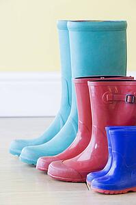 Three Pairs Of Colorful Gumboots In A Row