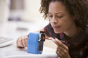 Woman in computer room using pencil sharpener