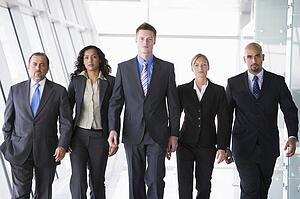 Group of co-workers walking in office space (high key)