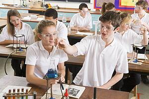 Students performing science experiments in classroom