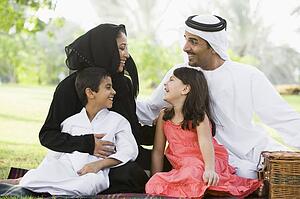 Family outdoors in park having a picnic and smiling (selective focus)