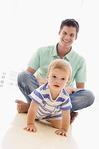 Father and baby indoors playing and smiling