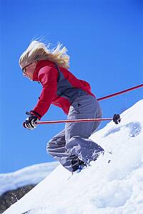 Skier coming down snowy hill (selective focus)