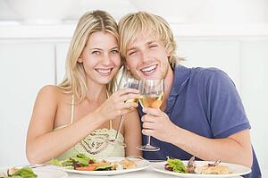 Young Couple Enjoying meal, mealtime With A Glass Of Wine