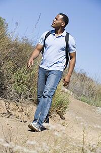 Man walking on path to beach