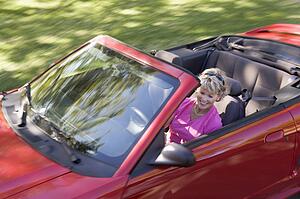 Woman in convertible car smiling