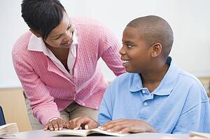 Student in class reading with teacher