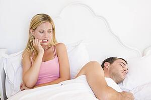 Young couple in bed having trouble sleeping