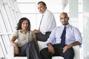 Three businesspeople sitting indoors (high key/selective focus)