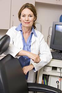 A Doctor Standing By A Computer Monitor