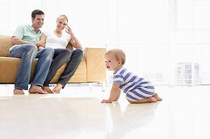 Couple in living room with baby smiling