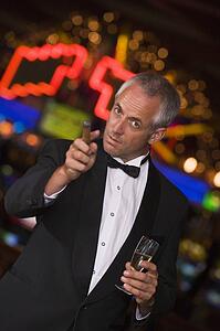 Man in casino with cigar and champagne pointing (selective focus)