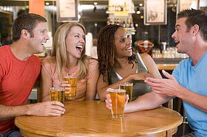 Two couples having beer together