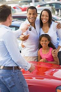 Mother and father with young daughter shopping for a new car