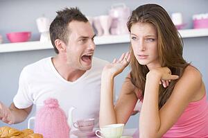 Young couple sitting at a table arguing