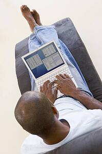 Man sitting in chair using laptop