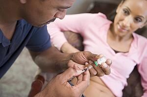 Man helping woman inject drugs to gain pregnancy (selective focus)