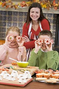 Mother and two children at Halloween playing with treats and smiling