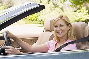 Woman in convertible car smiling