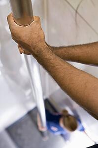 Shot of fireman's hands on a fire pole with firewoman at bottom (selective focus)