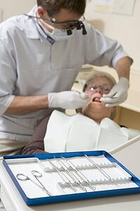 Dentist in exam room with woman in chair