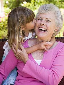 Grandmother getting a kiss from granddaughter.