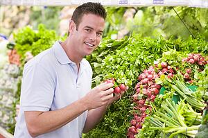 Man shopping for beets at a grocery store