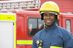 Fireman standing by fire engine wearing helmet