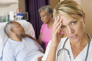 Doctor With Headache In Patients Room
