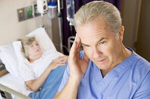 Doctor Standing In Patients Room, Looking Frustrated