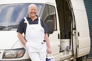 Painter standing with van smiling