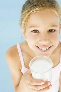 Young girl with glass of milk smiling