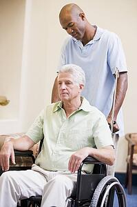 Nurse Pushing Man In Wheelchair