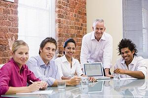 Five businesspeople in boardroom with laptop