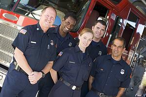 Five firefighters standing in front of fire engine