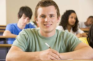 Student in class taking notes (selective focus)