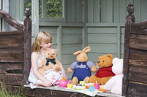 Young girl in shed playing tea and smiling