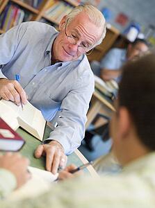 Two men in library with notepads talking (selective focus)