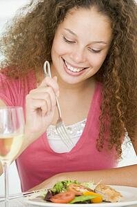 Woman Eating meal, mealtime With A Glass Of Wine 