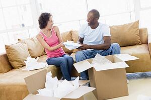 Couple unpacking boxes in new home smiling