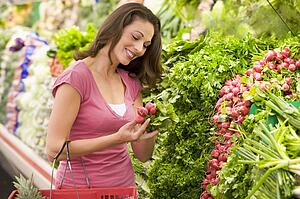 Woman shopping for beets at a grocery store