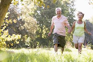 Couple running in park holding hands and smiling