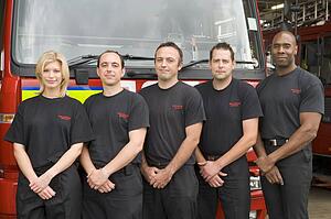 Five firefighters standing in front of fire engine