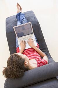 Woman sitting in chair using laptop