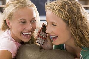 Teenagers Hanging Out In Front Of Television Using Mobile Phones 
