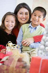 Mother With Her Daughter And Son Holding Christmas Gifts