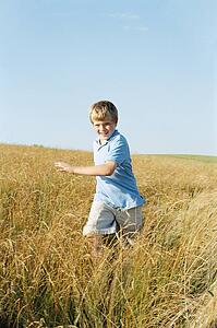 Young boy running outdoors smiling