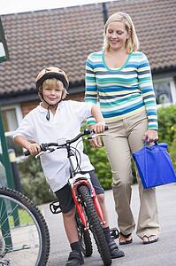 Mother and son outside school with bicycle
